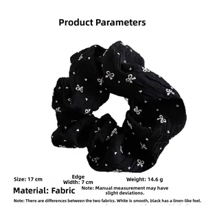 Vue détaillée du chouchou noir à motifs de nœuds blancs, mesurant 17 cm de diamètre
