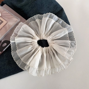 Close-up of white double-layered mesh scrunchie with delicate ruffled wave edges