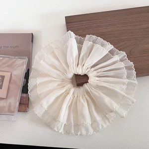 Detail view of large white double-layer mesh hair scrunchie on a minimalist wooden tray