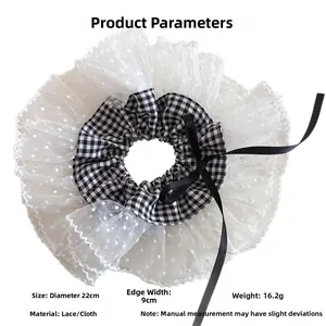 Détail d'un chouchou en dentelle à pois de 22cm avec tissu à carreaux noir et blanc