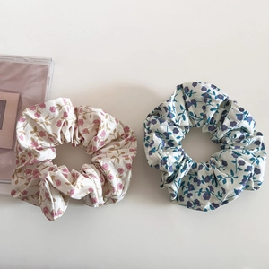 Détail de chouchous à fleurs en coton crème et bleu clair avec des plis doux