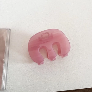 Close-up of translucent pink jelly hair claw clip with silver metal spring mechanism