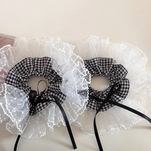 Détail du chouchou à carreaux avec dentelle à pois blancs et long ruban noir en nœud