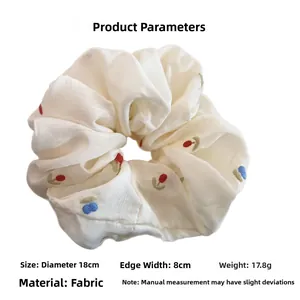 Detailed view of large white scrunchie with embroidery and 18cm diameter specs