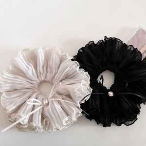 Detail of ruffled chiffon hair scrunchies with rhinestone bows in black and beige