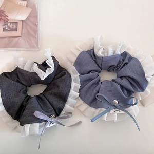 Detail of grey and blue ruffled scrunchies with elegant ribbon bows and metal charms