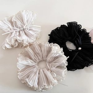 Detail of layered pleated organza scrunchies with rhinestone bows in three soft colors