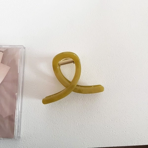 Detailed top view of an olive green jelly-colored hair claw clip with golden metal spring