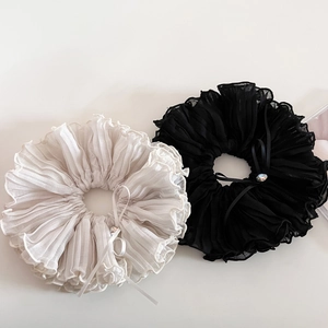 Detail of layered ruffle scrunchies with chiffon texture and rhinestone bow accents