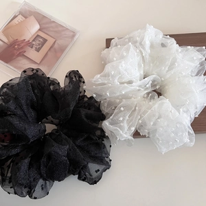 Detail view of large fluffy mesh scrunchies with elegant polka dots in black and white