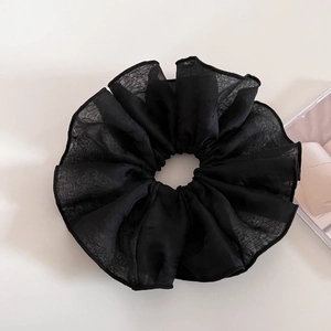 Detail shot of large black organza scrunchie with sheer texture and wavy pleated edges