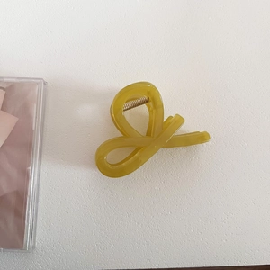 Detailed top view of olive green translucent hair claw clip with golden metal spring