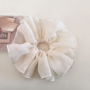 Macro view of white organza scrunchie with layered pleats and fine stitched edges