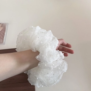 Oversized white mesh scrunchie with polka dots shown on wrist in French style