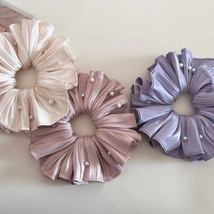 Detaillierte Makroansicht perlmuttfarbener Falten-Scrunchies mit eleganten Kunstperlen