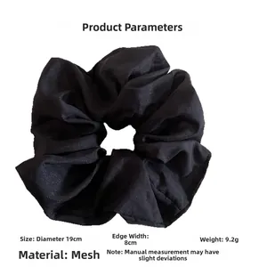 Détail montrant la taille 19cm et le matériau en gaze noire du grand chouchou à cheveux
