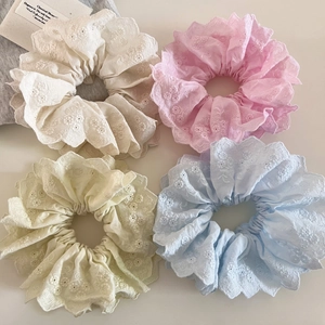 Détail de chouchous en dentelle double épaisseur à quatre couleurs avec broderie florale