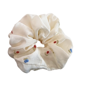 Elegant beige scrunchie with colorful floral embroidery on soft cotton fabric