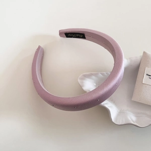 Close-up of sparkling pink satin headband with rhinestones and elegant interior label