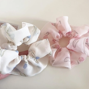 Dettaglio degli elastici scrunchie in rete a doppio strato con stampa floreale di tulipani
