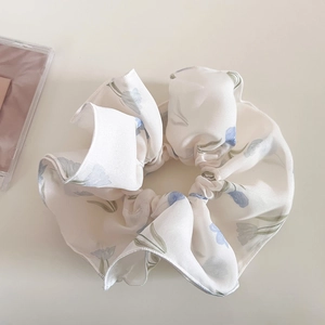 Dettaglio di un elastico per capelli a doppio strato in mesh con motivi di tulipani blu