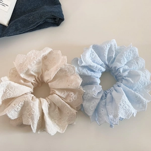 Détail de chouchous en dentelle double épaisseur avec broderie florale beige et bleu