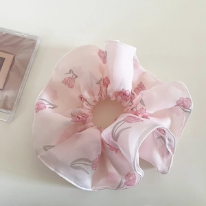Dettaglio di un elastico per capelli in chiffon rosa con delicate stampe di tulipani