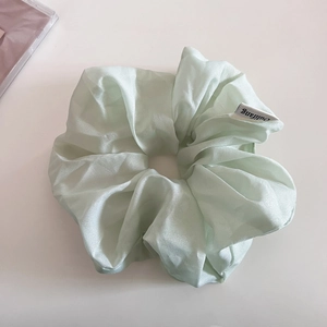 Vue détaillée du chouchou en organza vert menthe avec une finition nacrée scintillante
