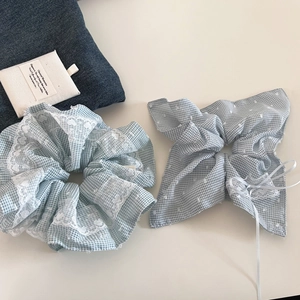 Detail van blauwe gingham scrunchie en haarelastiekje met kant en polkadot strik