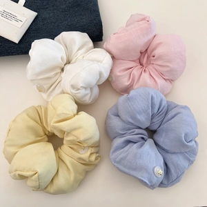 Set of four soft cotton puff scrunchies in pastel colors with small bow button details