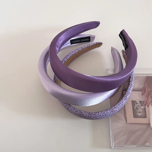 Détail de trois serre-têtes en éponge violette avec étiquettes faites à la main
