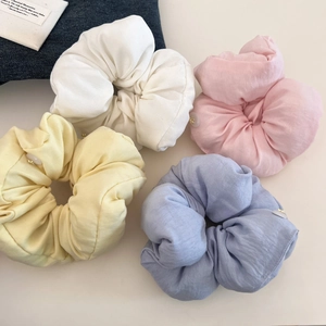 Flat lay view of soft oversized scrunchies in pastel colors with decorative buttons