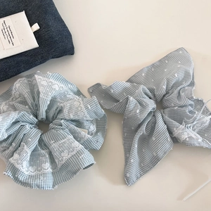Detail van lichtblauwe ruitjes haarelastiekjes met witte kant in een set van twee
