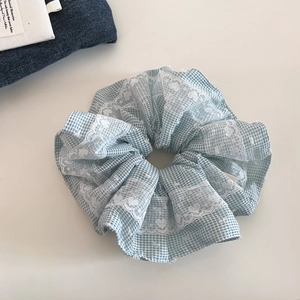 Blauwe geruite haarscrunchie met kanten randdetails op een witte achtergrond