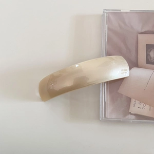 Detail of handmade cream acetate hair clip showing high-gloss finish and French craft
