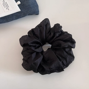 Elegant black mesh scrunchie with subtle polka dots for minimalist hair styling