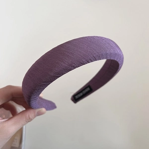 Vue détaillée du serre-tête en éponge violette avec tissu côtelé et étiquette intérieure