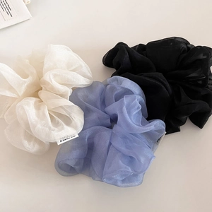 Détail de chouchous en organza nacré aux couleurs ivoire, bleu brumeux et noir
