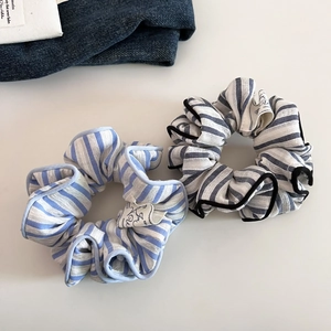 Detail of blue and black striped scrunchies with lace trim and hand made cloth labels
