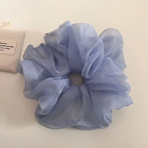 Détail du chouchou XXL en organza bleu clair nacré avec une texture douce et plissée