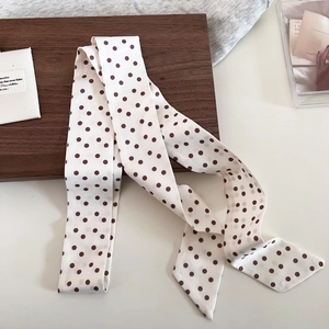 Detailansicht des seidigen Retro-Punkt-Schals mit eleganter Textur auf Holz