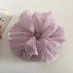Détail du chouchou en tulle nacré lavande montrant la texture douce et l'éclat de la soie