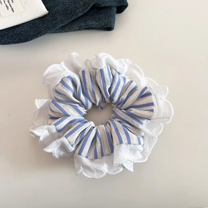 Detailed close-up of blue and white striped scrunchie with delicate white lace edging