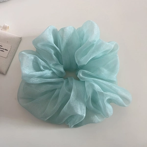 Détail de la texture d'un chouchou en organza bleu clair avec un fini nacré doux