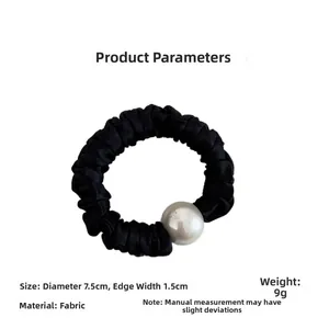 Detail shot of black pleated hair scrunchie with white pearl showing 7.5cm size and fabric