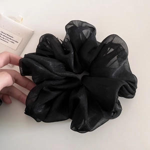 Gros plan d'un chouchou géant en organza noir aux plis transparents et à la texture soyeuse