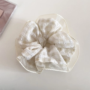 Dettaglio dell'elastico per capelli a quadretti crema con bordi in organza velata