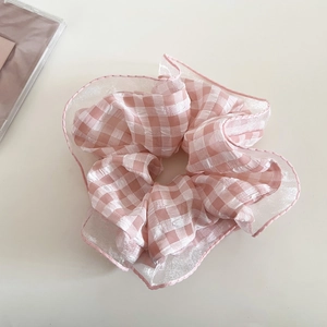 Dettaglio di elastico scrunchie a quadretti rosa con bordi in organza e volant dolci