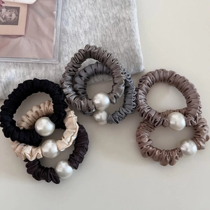 Lustrous pleated satin scrunchies with large pearl accents in assorted neutral colors