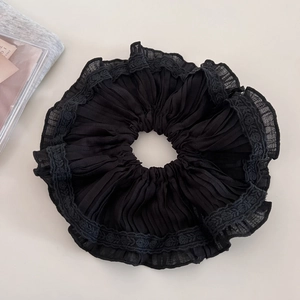 Detail of black pleated chiffon scrunchie with intricate lace trim for hair styling